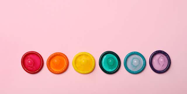 A row of rainbow-coloured condoms