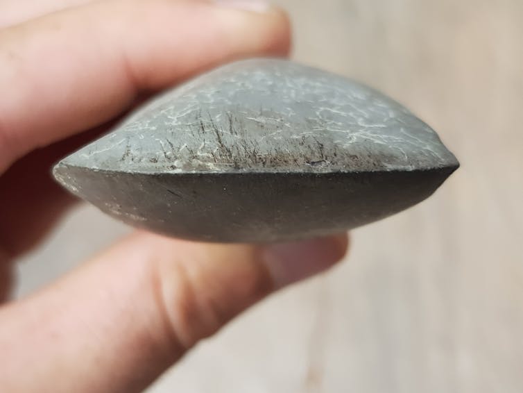 Hand holding a prehistoric stone axe