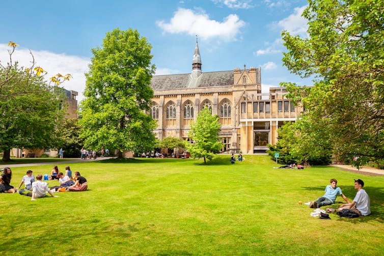 Students sitting on grass outside Balliol College, Oxford.
