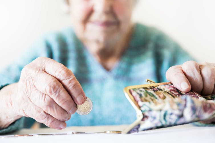 Elderly woman counting the money in her purse.