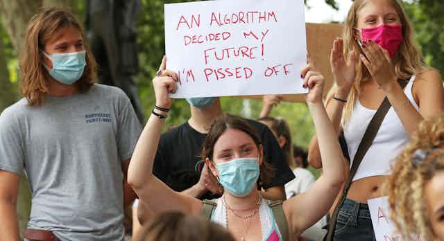 Young woman in protest group holds up sign.