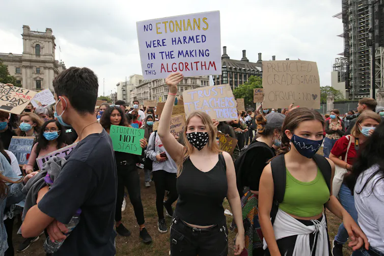 Teenagers marching in protest holding signs