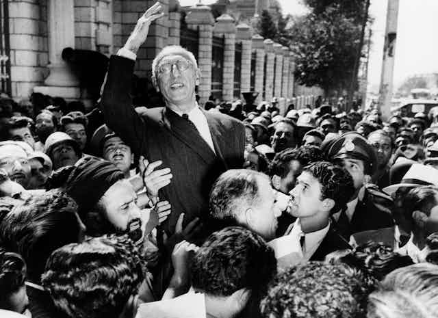 Prime Minister Mohammad Mosaddegh rides on the shoulders of cheering crowds in Tehran's Majlis Square in 1951.