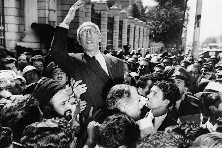 Prime Minister Mohammad Mosaddegh rides on the shoulders of cheering crowds in Tehran's Majlis Square in 1951.
