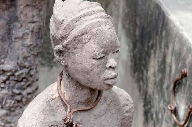 A statue of a woman with a chain around her neck.