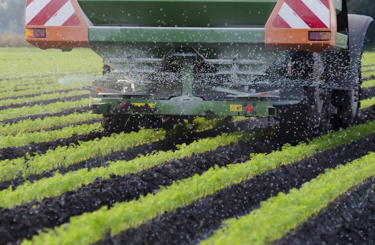 Farm machinery spreading fertiliser