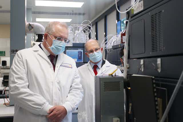 Scott Morrison and Paul Kelly, wearing lab coats, in a laboratory
