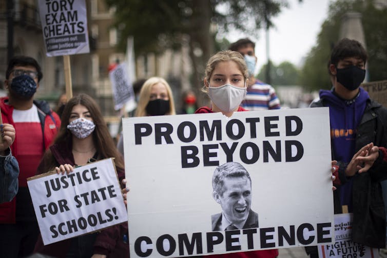 Students protesting, wearing face masks and holding signs