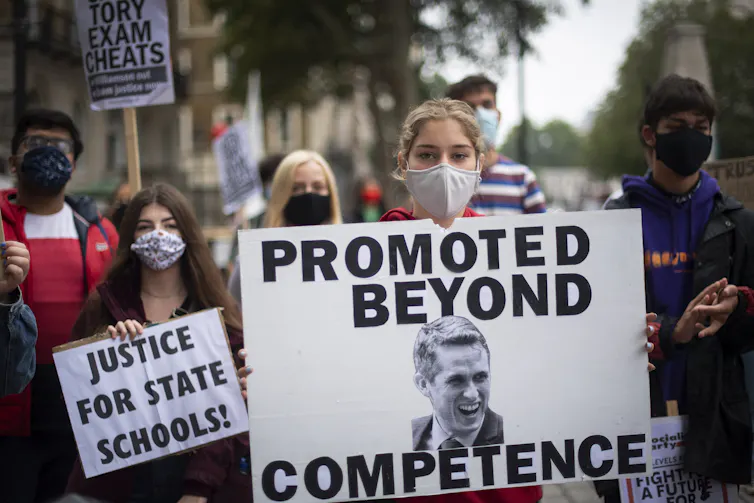 Students protesting, wearing face masks and holding signs