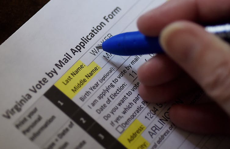 Voter filling out a Virginia ;vote-by-mail application.