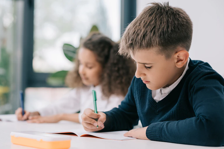 School children writing in workbooks