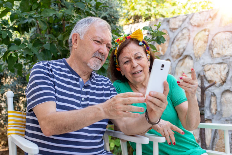 Una pareja madura mira un teléfono móvil.