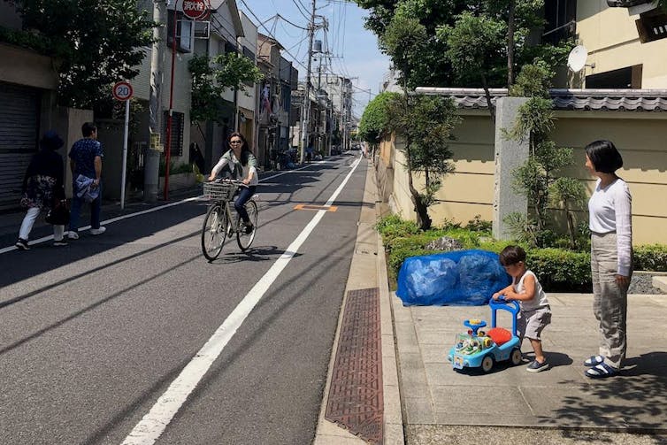 A young woman riding her bicycle with no other traffic on the road.