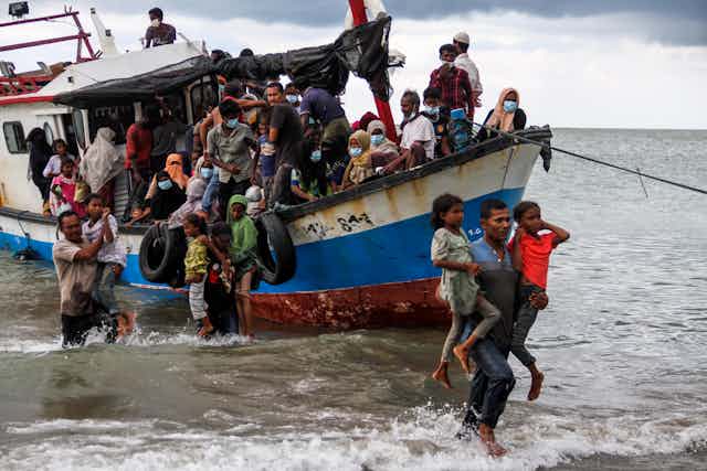Rohingya refugees evacuated from a boat as they arrive at Lancok beach, North Aceh, Indonesia
