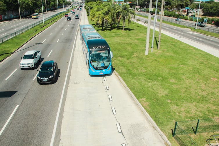 A bus passes through a dedicated lane beside two lanes full of cars.