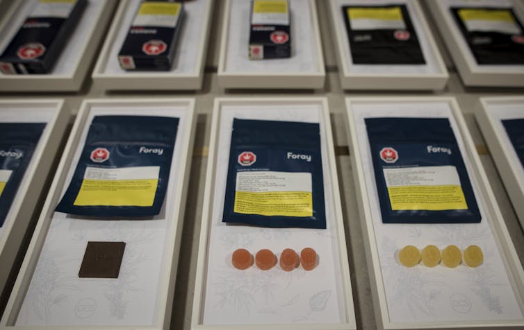 Display of different types of marijuana edibles, including dummies and chocolate squares, along with their packaging.