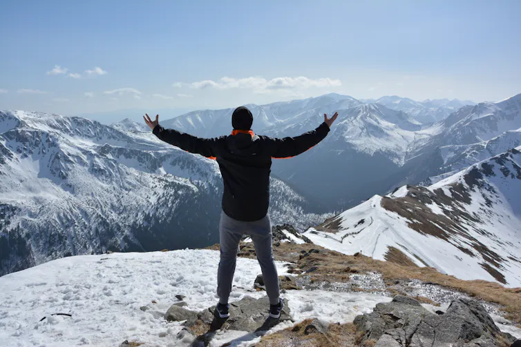 Man standing at the top of a mountain
