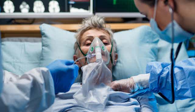 A person in intensive care being given oxygen.