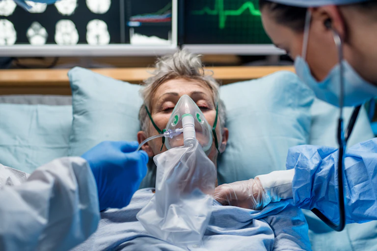 A person in intensive care being given oxygen.