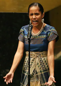 Kathy Jetñil-Kijiner speaks into a microphone.