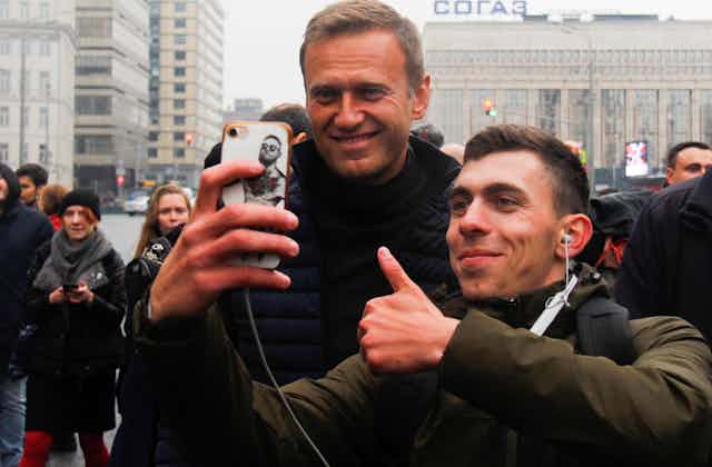 Russian opposition leader Alexei Navalny (L) poses for a photo at a Moscow rally