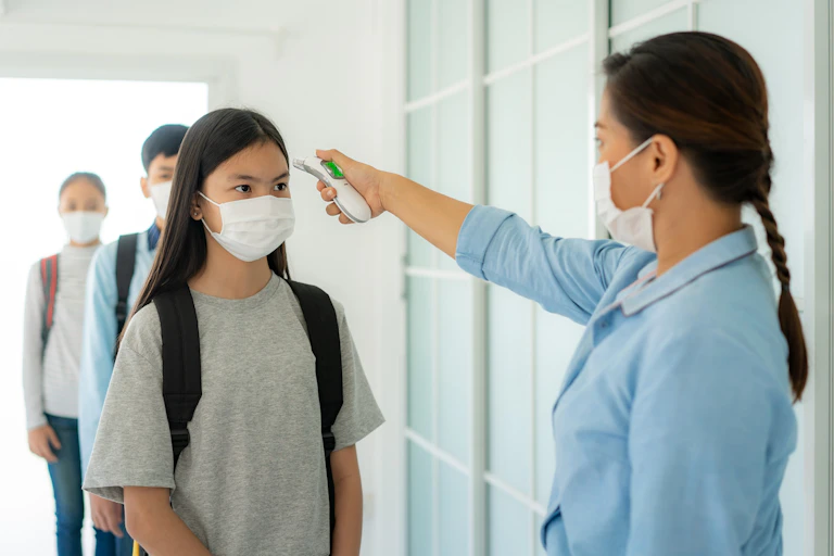 Screening students for COVID-19 symptoms at school.