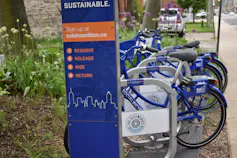 Bikes in a bike share are seen on a rack.