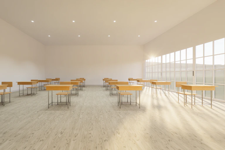 Aula con pocas mesas y sillas y muy luminosa.