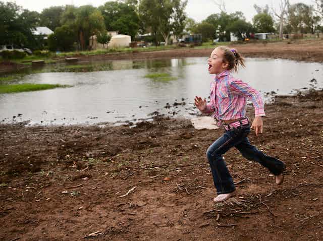 Girl funning on a farm after rain