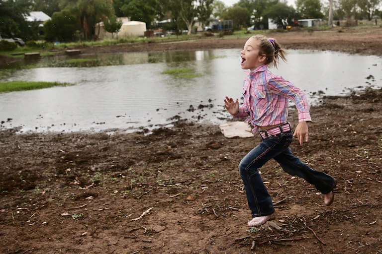 Girl funning on a farm after rain