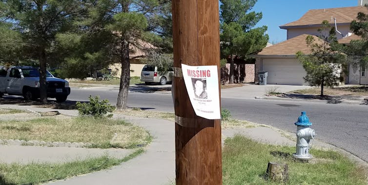 A missing persons sign on a telephone pole.