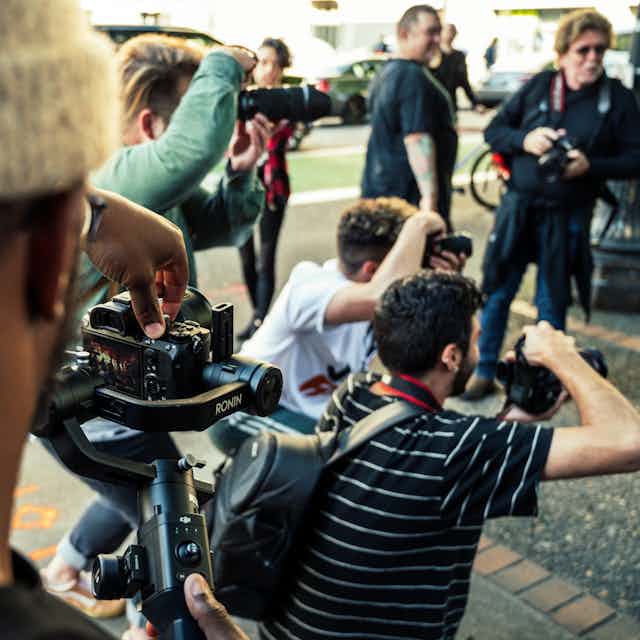 Photographers at an outdoor media conference