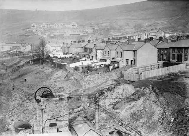 Black and white photograph of a colliery village built up around a coal mine. 
