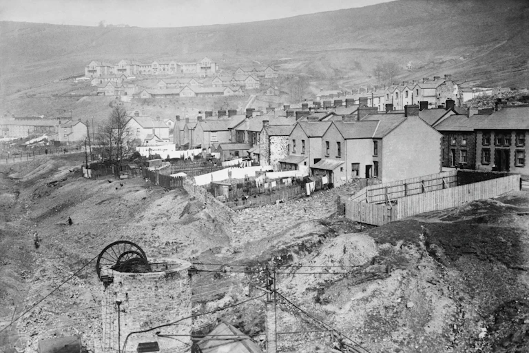 Black and white photograph of a colliery village built up around a coal mine.