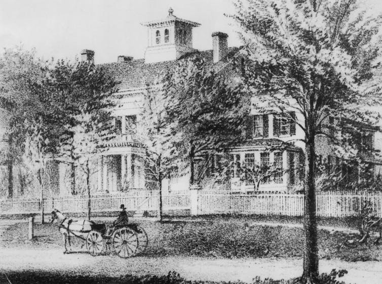 A horse-drawn carriage passes by Emily Dickinson's home in Amherst, Mass.