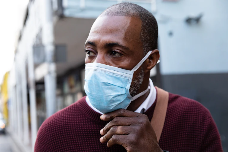 A Black British man wearing a mask