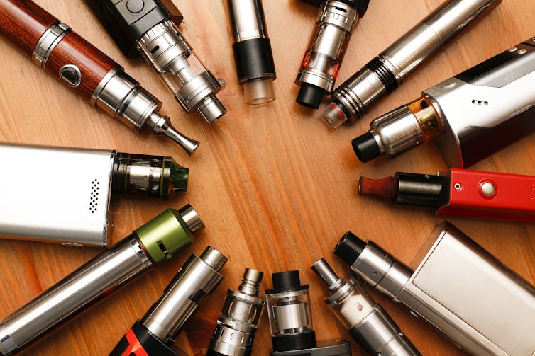A number of vaping devicse and accessories arranged in a circle.
