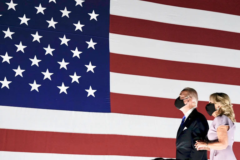 Us presidential nominee Joe Biden and wife Jill stand in front of a US flag