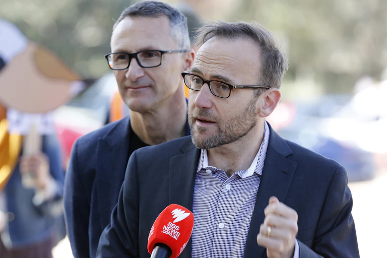 Adam Bandt speaking at a press conference with Richard Di Natale standing behind