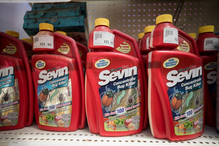 Red bottles of weed killer on store shelf.