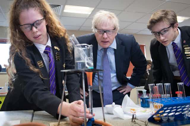 Boris Johnson and two school children looking at a science experiment