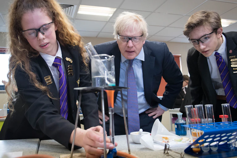 Boris Johnson and two school children looking at a science experiment