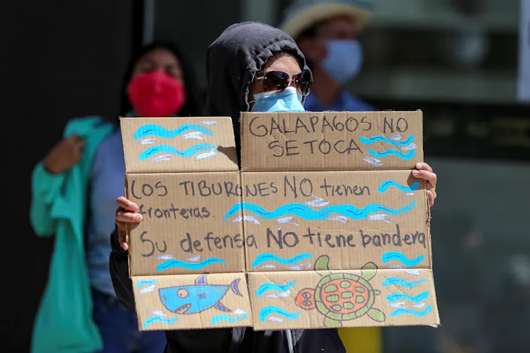 Protester holds up a sign against Chinese fishing.