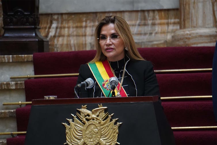 A woman stands at a podium giving a speech.