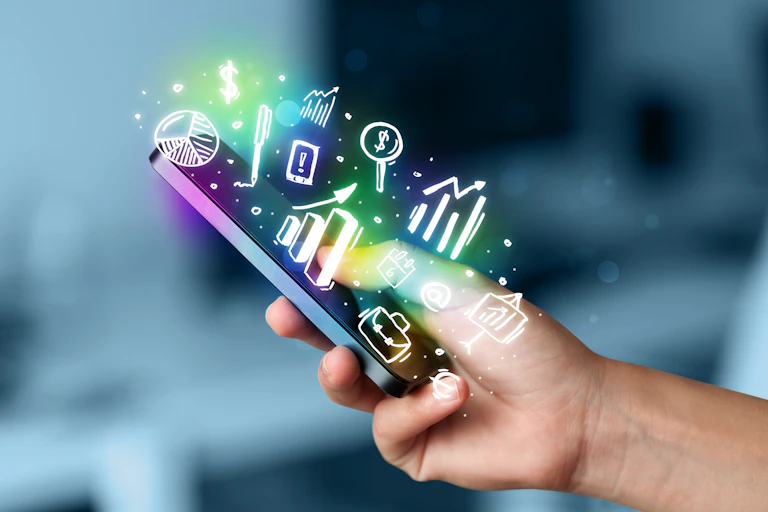 Hand holding phone with an array of finance things coming out of it.