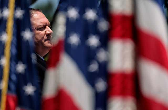 Mike Pompeo surrounded by US flags