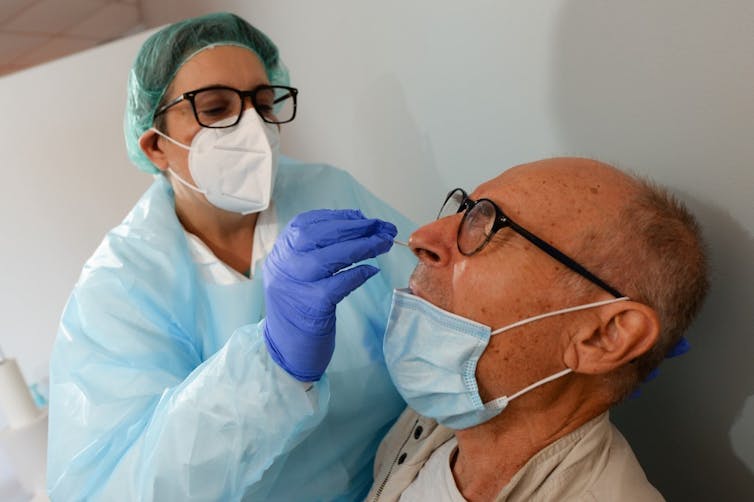 Une professionnelle de santé prélève un échantillon par écouvillonnage dans un centre de test Covid-19, au Mans, le 21 août 2020.