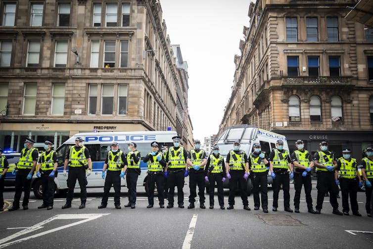 A row of police officers standing in city street.