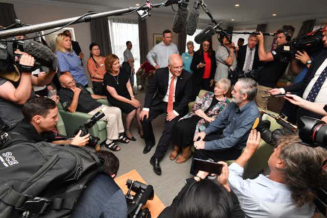 Scott Morrison, surrounded by journalists, at an aged care centre
