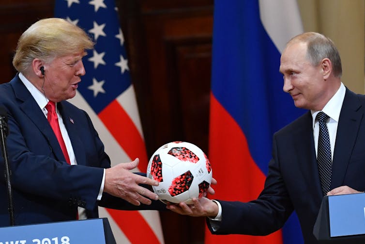 Russia's President Vladimir Putin offers a 2018 football World Cup ball to US President Donald Trump.